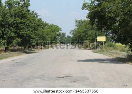 road with sign pole between trees and car