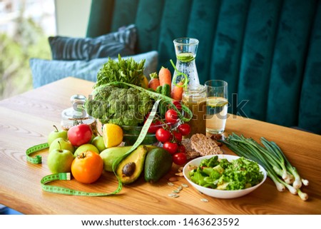 Diet weight loss breakfast concept with tape measure, organic fruits , vegetables, salad and fresh water. Healthy nutrition concept, Lifestyle and Eating