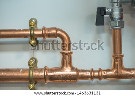 Copper pipework with isolator valve, close up view. Royalty-Free Stock Photo #1463631131