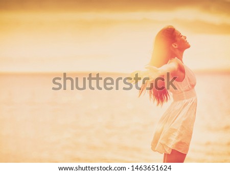 Wellness woman feeling free with open arms in freedom side profile silhouette on ocean beach background. Stress free happy emotion people. Royalty-Free Stock Photo #1463651624