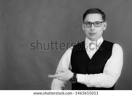 Photography in the Studio. A young man with glasses, wearing a shirt and a vest.