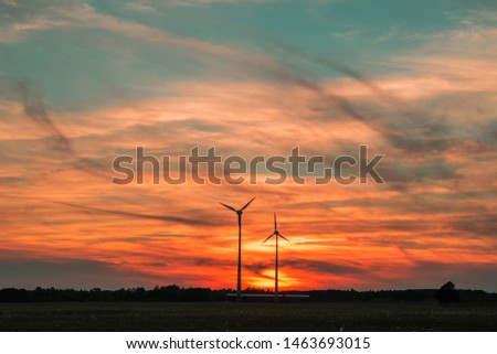 Silhouettes of wind turbines creating alternative and renewable energy during beautiful sunset near Liepaja, Latvia