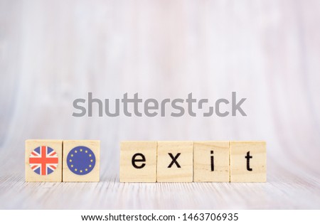 Brexit concept .Exit word written on wood blocks with British and EU flags. Exit text on wooden table for your desing