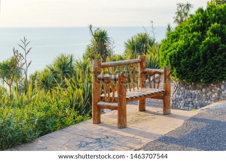 Bamboo bench with a palm trees background 