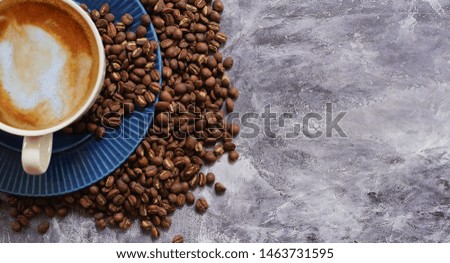  A cup of fresh coffee and roasted coffee beans on the old cement floor