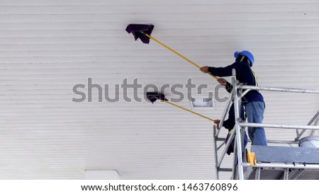 2 Cleaner Workers on scaffolding using mops to Cleaning white Ceiling Roof of petrol station, low angle view with copy space Royalty-Free Stock Photo #1463760896