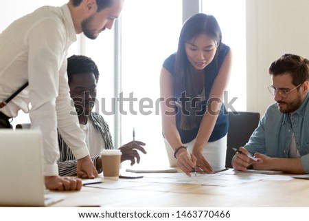 Focused diverse business executive team people designers architects with female asian leader manager discuss paperwork financial report brainstorm work together at group corporate office meeting Royalty-Free Stock Photo #1463770466