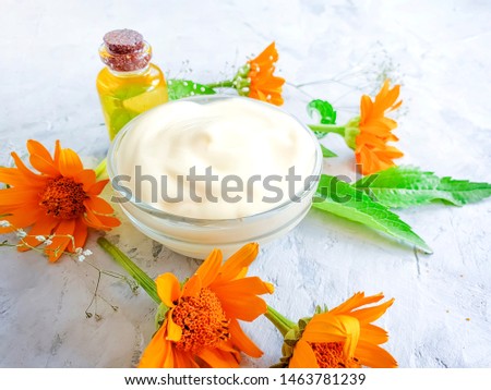 cream cosmetic flower calendula on gray concrete background