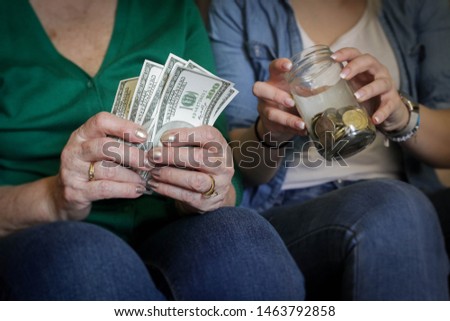 Close up photo fo senior and young female hands holding money.