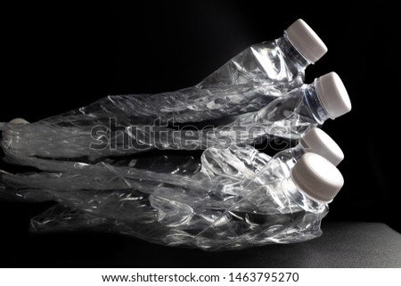 Compressed Plastic Drinking Water Bottle on iSolated Black Background. Recycle Concept Picture.