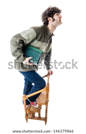 an handsome guy, maybe a student, in casual clothing clambering on a small wooden library ladder. isolated on white