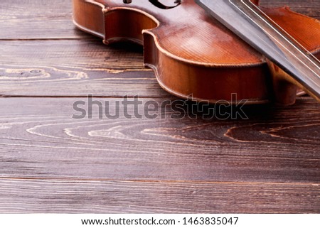 Vintage violin and copy space. Aged cello on textured wooden background. Orchestral musical object.