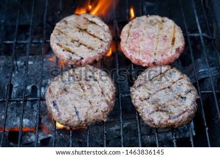Burgers cooking on a BBQ in the summer