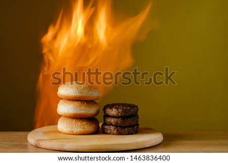 
bun and patties for burgers on fire background