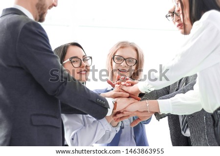 business team showing their unity while standing in the office