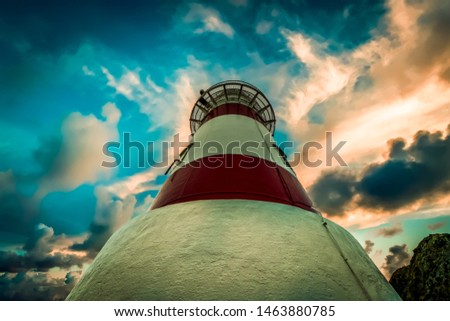 Looking up the lighthouse to stormy skies above