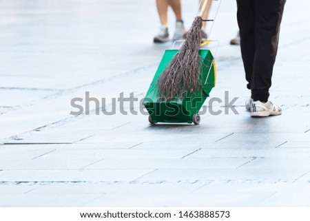Cropped Man Walking down the Street Holding Wooden Broom