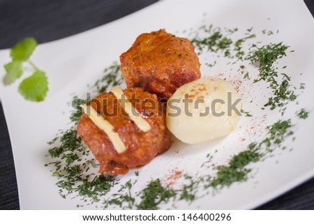 Close up picture of meatbalss plate with a potato