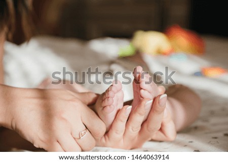 maternal care. mother and child. mother's love mothers Day. newborn. baby feet in mom's hands close up