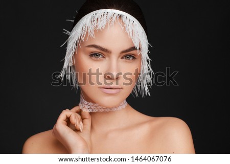 Beauty portrait of a beautiful woman using white lace ribbon. Black background. Studio photo session