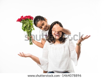 Mother's Day - Indian girl / mother celebrating Mother's day with Rose Flower Bouquet, greeting card while hugging and kissing each other