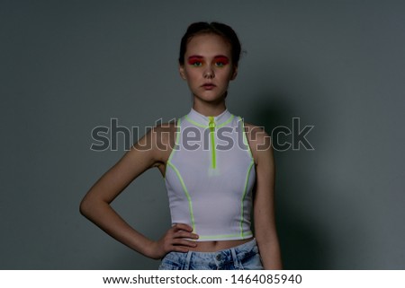 serious woman holds hand on belt on gray background