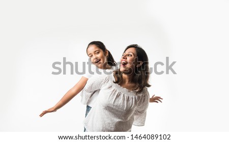 Indian mother daughter on white background hugging, kissing, riding, flying, pointing, presenting over white background