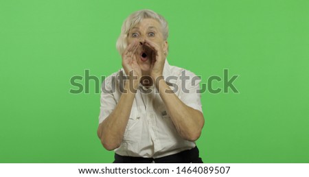 An elderly woman shouts. Old pretty grandmother in a white shirt. Place for your logo or text. 