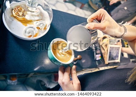 professional service at cafe concept. coffee house. Barista Making of cafe latte art. pouring milk in glass of fresh made coffee. Milk coffee toned picture. Hand of Barista making latte or cappuchino