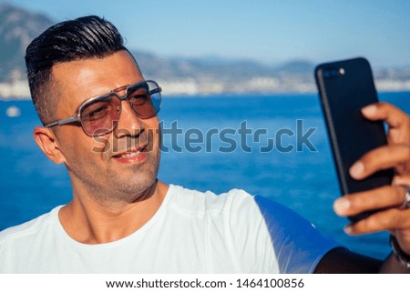 handsome turkish male making selfie photo portrait on camera smartphone in Turkey beach.