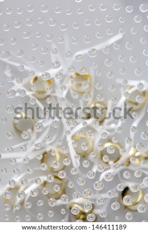 Waterdrops picturing some wedding rings 