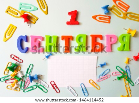 Word September 1 in Russian on a white sheet of paper with paper clips and pins. Back to School concept.