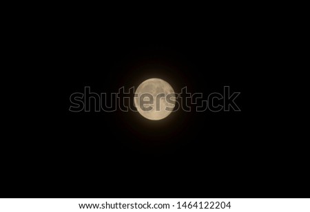 The moon over dark black sky at night.