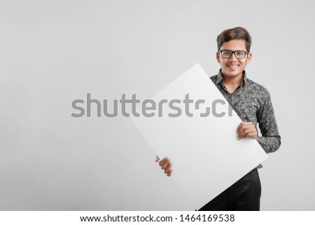  Indian/Asian Male college student showing blank signboard 