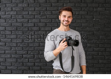 Young male photographer on dark background