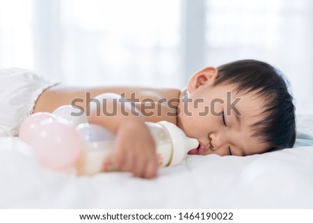 Baby sleeping on a bed after drinking bottle milk