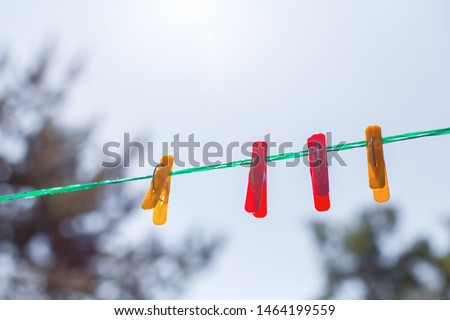 four color pins on a green rope against the sky, retro