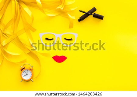 Decorative cosmetic for make up with face model on yellow background top view mock up
