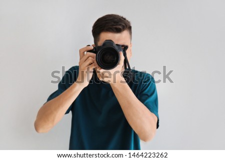 Male photographer on light background