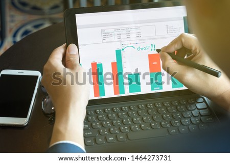 businessman using  drawing comment in tablet for analysis graph visualization at coffee shop
