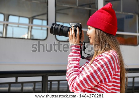 Young female photographer on embankment