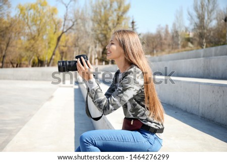 Beautiful female photographer in park