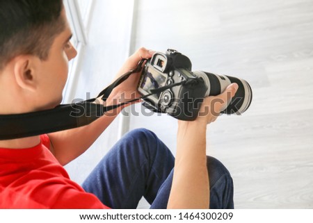 Male photographer with camera indoors