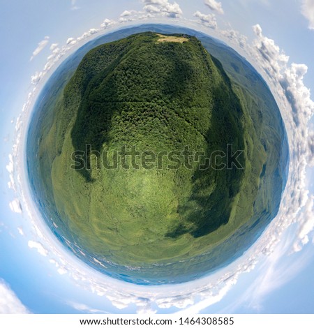 drone aerial view - small planet - forest green deciduous forest near the mountain with a meadow on the top - with a big shadow of a cloud - on a sunny July day