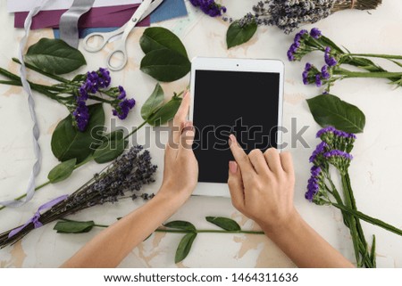 Female florist with tablet computer at workplace