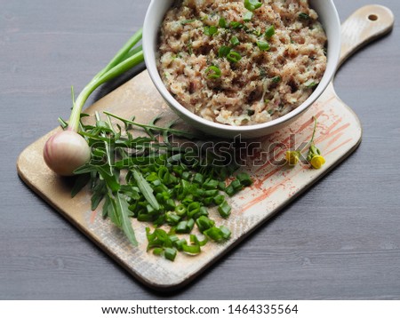 Green onions, spicy herb arugula, raw minced meat in a plate on the original Board. Delicious and simple recipe for juicy filling for hamburgers, cutlets, pies, rolls, pita, casserole, burger, chop.