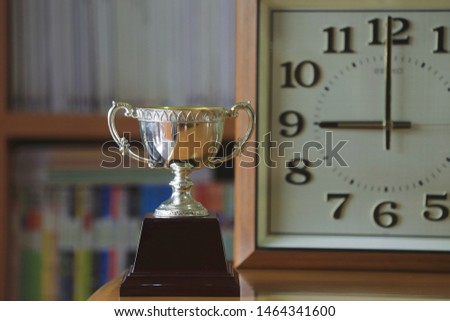 Close-up of antique trophies on the table Antique wooden clock as background selective focus and shallow depth of field