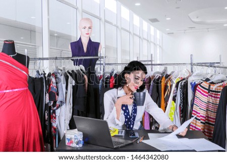Picture of female fashion designer drinking a cup of tea while relaxing in the workplace