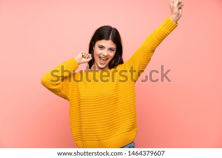 Teenager girl  over isolated pink wall celebrating a victory