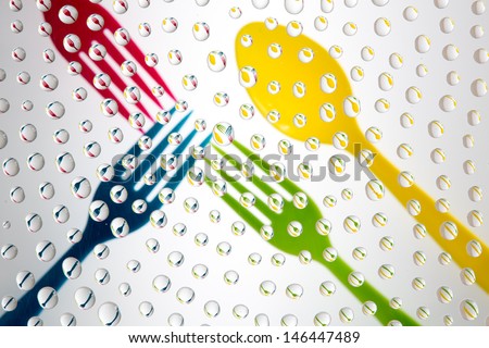 Waterdrops picturing three colored forks and a spoon